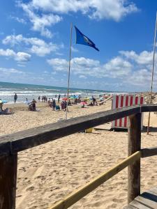 a blue flag on a beach with people on it at Villa Vista Mar La Marina Piscine privée in Elche
