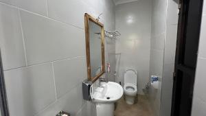 a bathroom with a toilet and a mirror on the wall at Kilimani Apartment in Arusha +17 photos