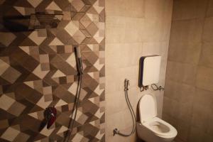 a bathroom with a toilet and a shower at The Lotus Resort Lonavala in Āmbavna