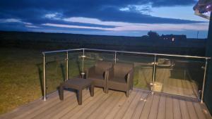 a balcony with a chair and a table on a deck at Shanadune in Tralee