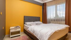 a bedroom with a bed and a yellow wall at No 232 Rezidans in Buca