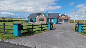 a house with a fence next to a road at Shanadune in Tralee