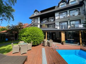 una casa con piscina y un edificio en Boho Łeba z basenem krytym i jacuzzi, en Łeba