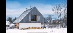 a small cabin in the snow with a window at Chalupa Záhorka in Orlické Záhoří 