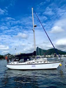 a white sail boat sitting in the water at Apartamento recreio in Rio de Janeiro
