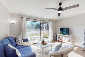 een woonkamer met een blauwe bank en een tv bij Cozy condo with shared pool, close to historic downtown st augustine in St. Augustine