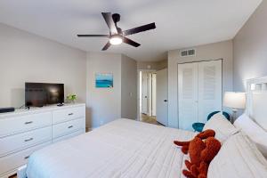 een slaapkamer met een bed en een plafondventilator bij Cozy condo with shared pool, close to historic downtown st augustine in St. Augustine +18 foto's