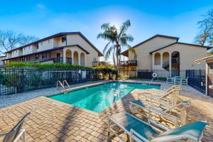 een zwembad met stoelen en een huis bij Cozy condo with shared pool, close to historic downtown st augustine in St. Augustine