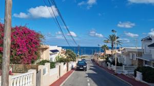 a car driving down a street next to the ocean at Apartament z widokiem na morze 250 m od plaży in Torrevieja
