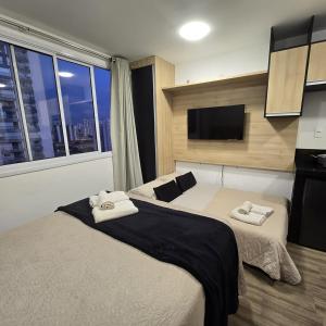 a hotel room with two beds and a flat screen tv at Moov Brás 159 B T2 - Rua Coronel Mursa, 56, Brás, São Paulo - Ap 159 B TORRE 2 - 15 ANDAR in Sao Paulo
