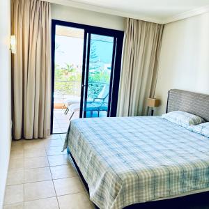 a hotel room with a bed and a balcony at Balcon De Los Gigantes in Puerto de Santiago +58 photos