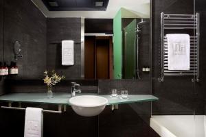 un baño con lavabo y espejo en NH Madrid Las Tablas, en Madrid