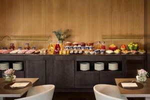 un buffet de comida en un restaurante con dos mesas en NH Madrid Las Tablas, en Madrid