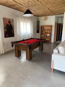 a living room with a pool table and a couch at Mar Egeu Arte & Pouso in Peruíbe