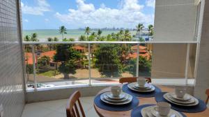 a dining room with a view of the ocean at Costa Serena Flats - Ponta de Campina in Cabedelo