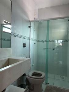 a bathroom with a shower with a toilet and a sink at Apartamento no centro de Garopaba bem próximo a praia in Garopaba +7 photos