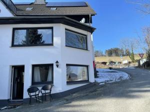 dos sillas sentadas fuera de una casa blanca en Appartement Welgelegen, en Bestwig