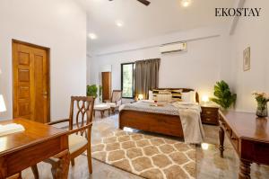 アリバグにあるEKOSTAY - Mercury Villaのベッドと机とテーブルのある寝室 +9枚の写真