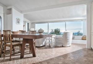 a dining room with a table and chairs and a large window at Villa Marinella in Barrabisa +58 photos