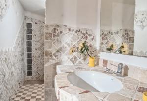 a bathroom with a large sink and a tiled floor at Villa Marinella in Barrabisa