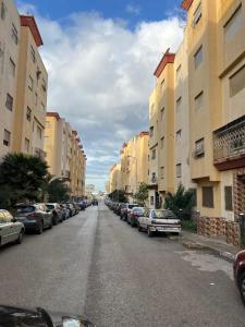 タンジェにあるCozy Stay near airportの建物の脇に車が駐車されている通り