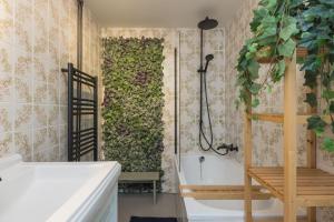 y baño con pared verde y bañera. en -Casa Como- nabij het meer, restaurants & keukenhof, en Noordwijkerhout