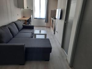 a living room with a couch and a table at Appartements et studios du Pilat in Saint-Julien-Molin-Molette