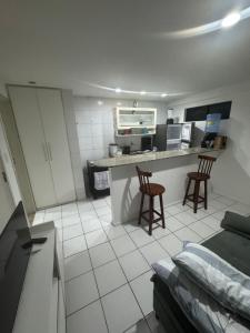 a kitchen with two chairs and a counter in a room at Ap studio a 50m da praia in Maceió