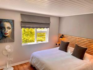 a bedroom with a large bed and a window at Stellenbosch Serenity in Stellenbosch