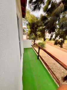 un suelo verde junto a un edificio con una valla en El silvio descanso, en Mar de Ajó 4 fotos más