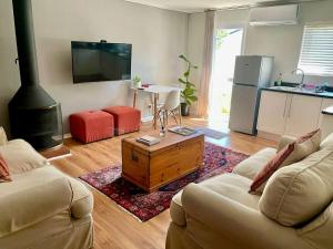 a living room with two couches and a stove at Stellenbosch Serenity in Stellenbosch