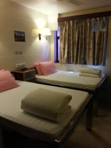 a hotel room with two beds and a window at Sun Shine Guest House in Hong Kong