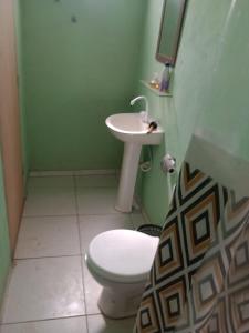 a bathroom with a toilet and a sink at Casinha Azul in Estrela