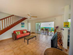 a living room with a couch and a table at villa Caraibes proche plage in Sainte-Anne