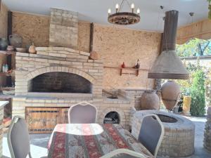 a kitchen with a stone fireplace and a table and chairs at Tevosyan Pluse Evn Airport in Pʼarakʼar