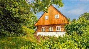 una grande casa in legno con tetto arancione di Roubenka mezi stromy s wellness a Mladé Buky