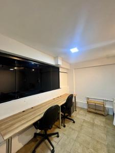 uma sala de conferências com uma grande secretária e duas cadeiras em Apartemento 101 em Brasília