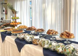a table with many plates of food on it at Hotel Bella Italia in Peschiera del Garda