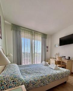 a bedroom with a bed and a large window at Hotel Bella Italia in Peschiera del Garda