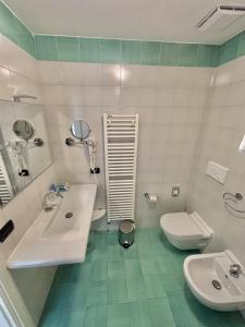 a white bathroom with a sink and a toilet at Hotel Bella Italia in Peschiera del Garda