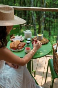 a woman sitting at a table with a plate of food at Wabi sabi lodge - spa&sauna privatif - forêt in Turenne +8 photos