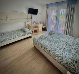 a bedroom with two bunk beds and a desk at Hotel Bella Italia in Peschiera del Garda