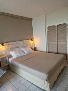 a bedroom with a large bed with two pillows at Ti Dyaman - Studio vue mer & accès piscine gratuit in Le Diamant