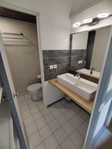a bathroom with a sink and a toilet and a mirror at Ti Dyaman - Studio vue mer & accès piscine gratuit in Le Diamant +12 photos