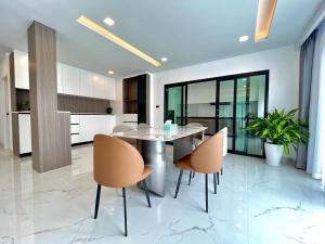 Un comedor con una mesa y sillas en una cocina. en 芭堤雅ins风独栋泳池别墅, en Nong Prue