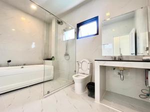 Un baño con bañera, inodoro y lavabo. en 芭堤雅ins风独栋泳池别墅, en Nong Prue