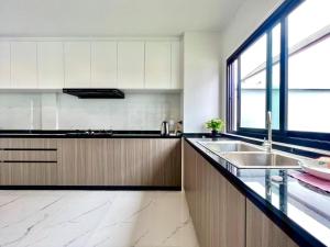 cocina con fregadero y ventana grande en 芭堤雅ins风独栋泳池别墅, en Nong Prue 9 fotos más