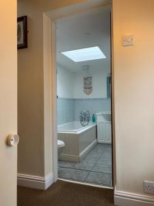 a bathroom with a tub and a toilet and a sink at Awd Tuts 17th Century Cottage by the harbour in Whitby +57 photos