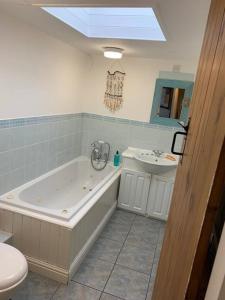 a bathroom with a large tub and a sink at Awd Tuts 17th Century Cottage by the harbour in Whitby