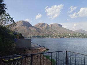 a view of a large body of water with mountains at Wakanda on Hartbeespoort Dam in Hartbeespoort